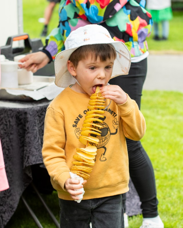 A boy enjoying his Curly Fries, at On the Fly River Festival in Gore Southland 