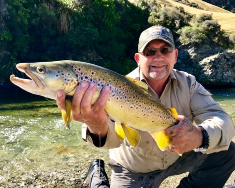 Mike smiling while holding a big fish he has caught fly fishing 